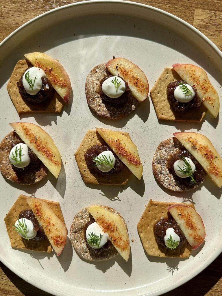 Small gourmet canapé bites served on a black plate